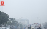 Người Hà Nội mặc thêm áo mưa ra đường vì lạnh